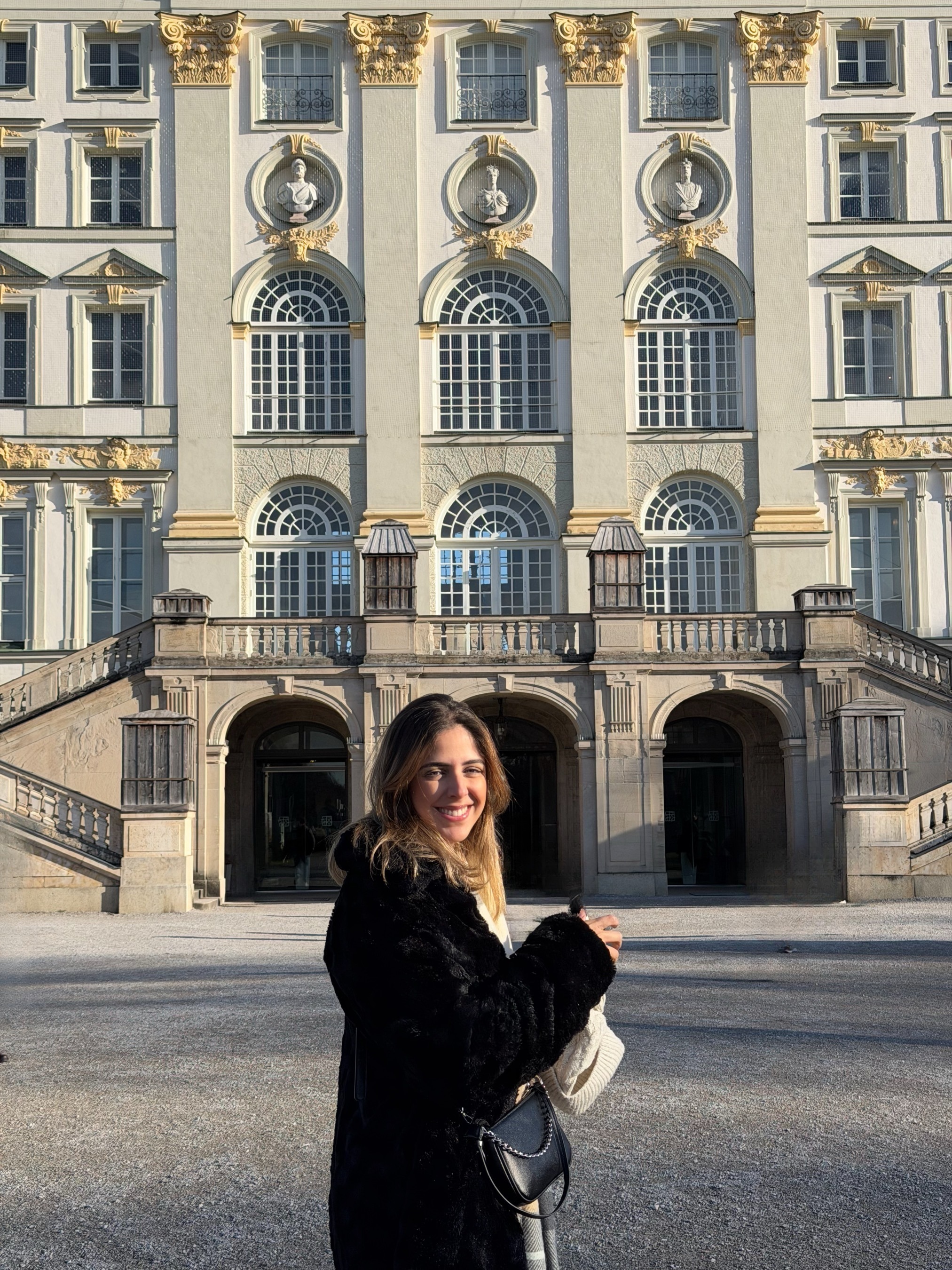 Paula Oliveira smiling in front of a baroque palace